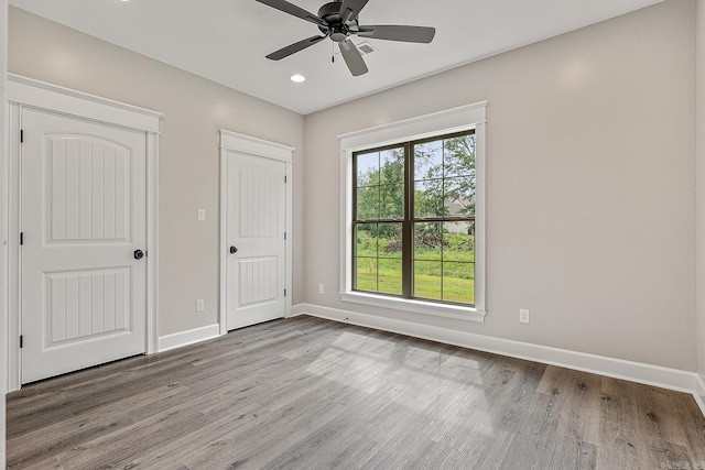 unfurnished bedroom with ceiling fan and light wood-type flooring