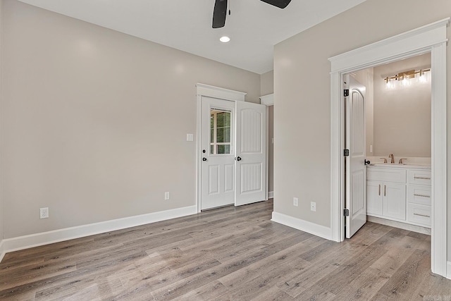 unfurnished bedroom with connected bathroom, light hardwood / wood-style flooring, and ceiling fan