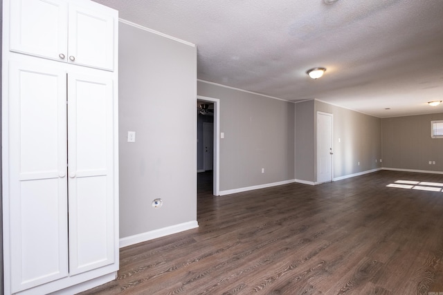 interior space with a textured ceiling, crown molding, and dark wood-type flooring