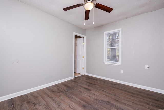 empty room featuring dark hardwood / wood-style floors, ceiling fan, and a textured ceiling