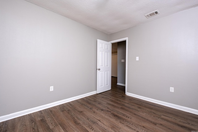 spare room with dark hardwood / wood-style flooring and a textured ceiling