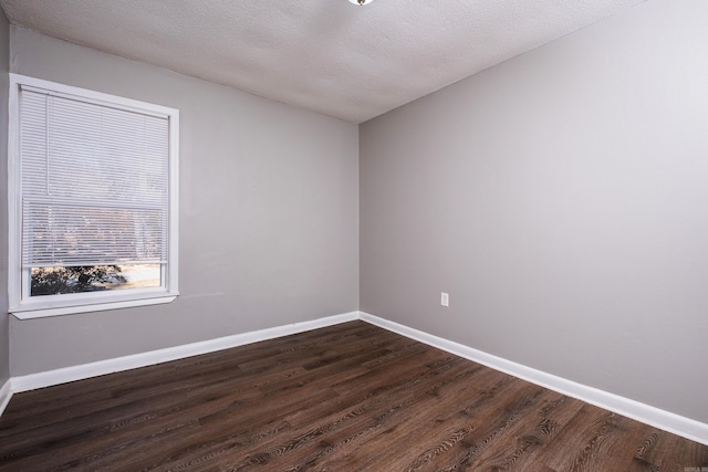 unfurnished room featuring a textured ceiling and dark hardwood / wood-style floors