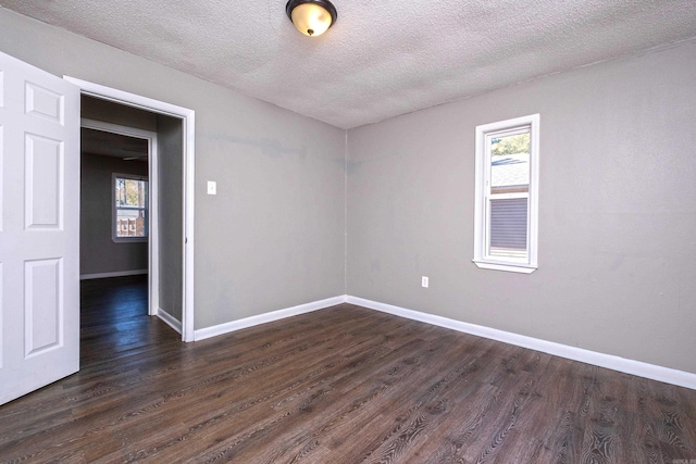 unfurnished room with dark hardwood / wood-style flooring and a textured ceiling