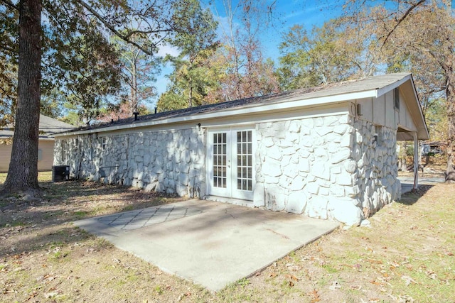 rear view of property featuring french doors, cooling unit, and a patio