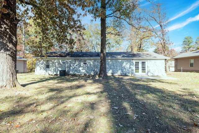 back of property featuring central air condition unit, a yard, and french doors