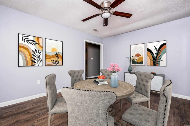 dining room featuring a textured ceiling, ceiling fan, and dark wood-type flooring