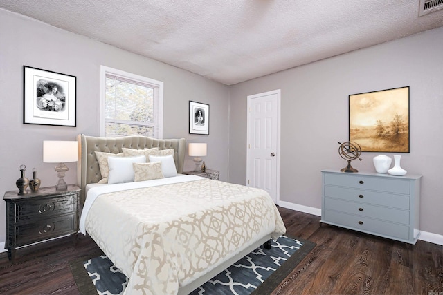 bedroom featuring dark wood-type flooring and a textured ceiling