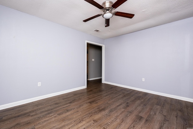 spare room with a textured ceiling, ceiling fan, and dark wood-type flooring