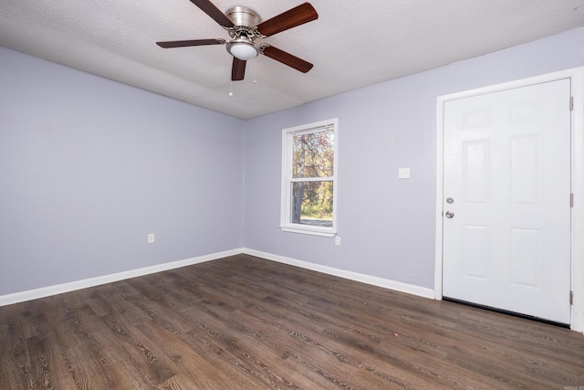 unfurnished room featuring ceiling fan, dark wood-type flooring, and a textured ceiling