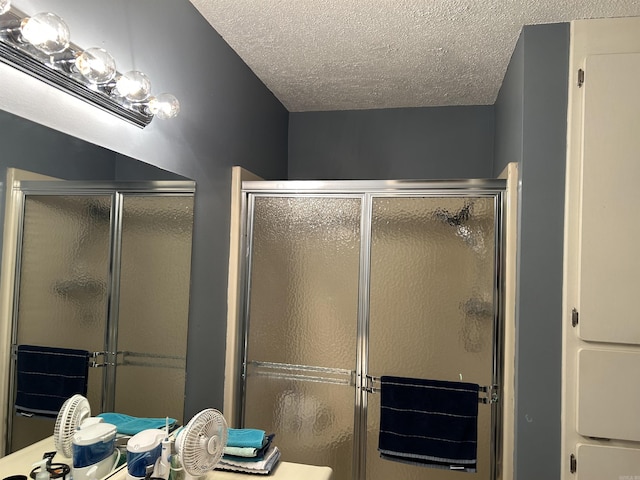 bathroom with a textured ceiling and an enclosed shower