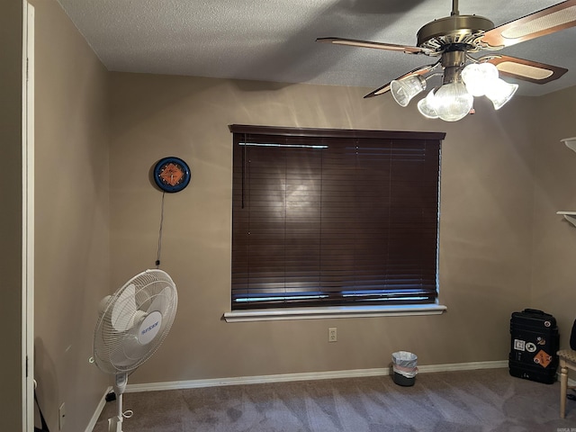 empty room with a textured ceiling, ceiling fan, and light carpet