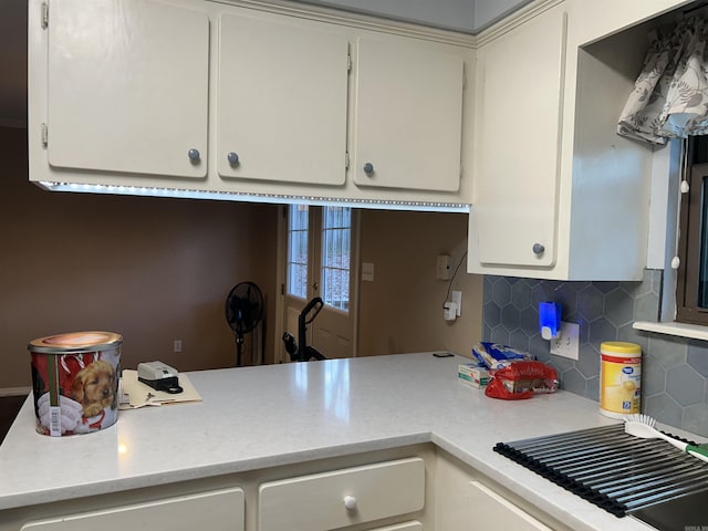 kitchen with decorative backsplash and white cabinetry