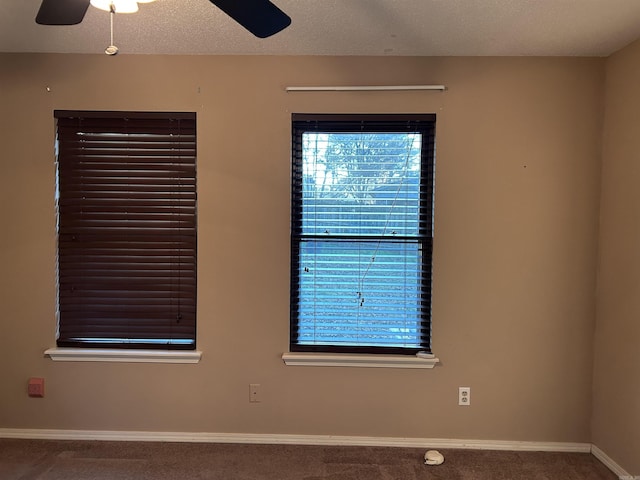 carpeted spare room with ceiling fan and a textured ceiling