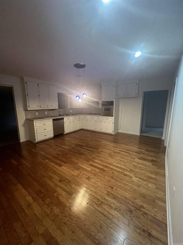 kitchen featuring appliances with stainless steel finishes, sink, pendant lighting, white cabinets, and dark hardwood / wood-style floors