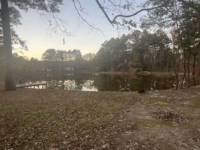 yard at dusk featuring a water view