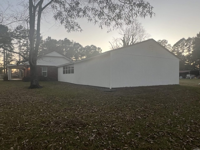 property exterior at dusk featuring a yard