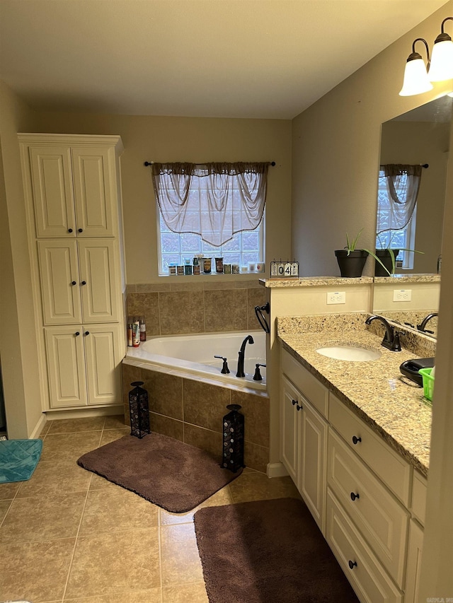 bathroom featuring tile patterned flooring, vanity, and tiled tub