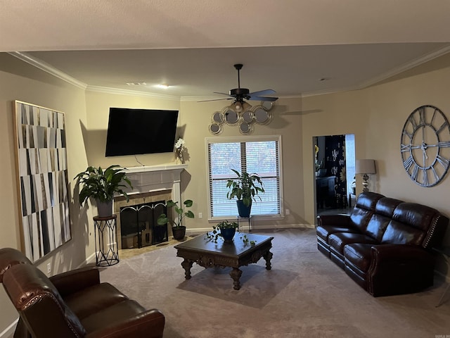 carpeted living room with a tile fireplace, crown molding, and ceiling fan