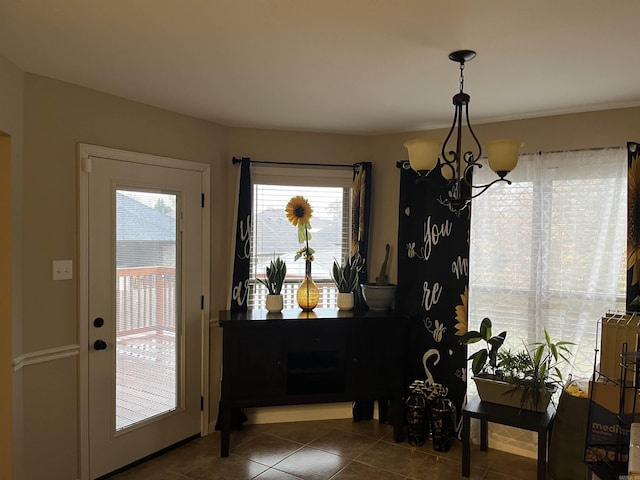 interior space featuring dark tile patterned floors and a notable chandelier