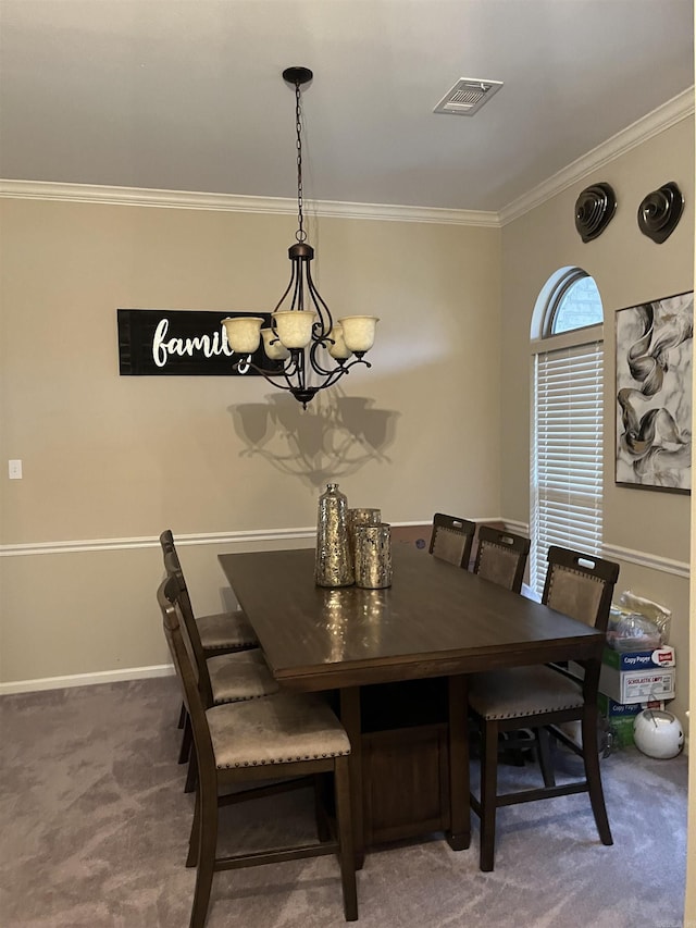 carpeted dining area featuring crown molding and a chandelier