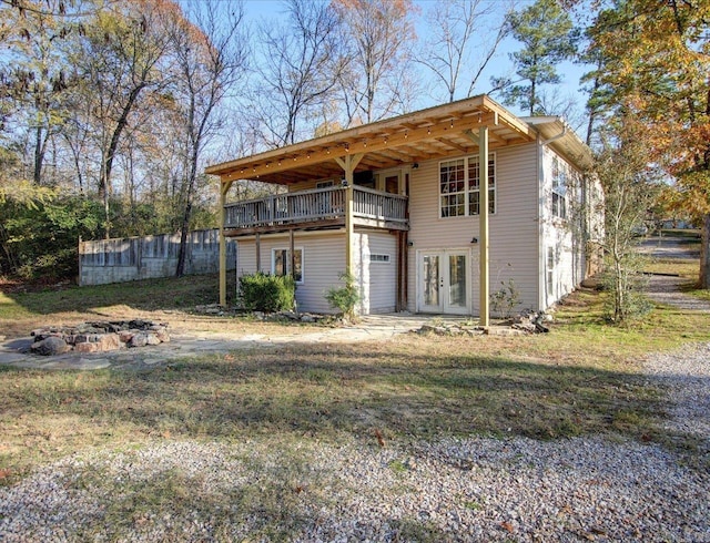 back of property featuring french doors and a lawn