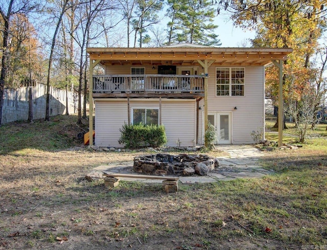 rear view of property featuring a deck and an outdoor fire pit