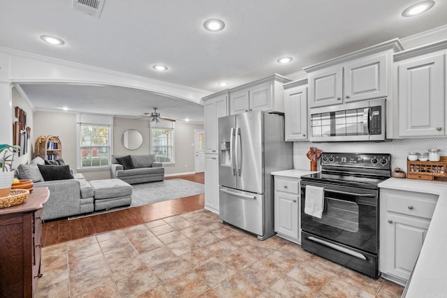 kitchen with crown molding, white cabinetry, stainless steel appliances, and light wood-type flooring