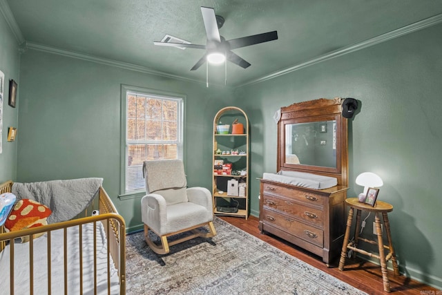 living area featuring hardwood / wood-style floors, ceiling fan, and ornamental molding