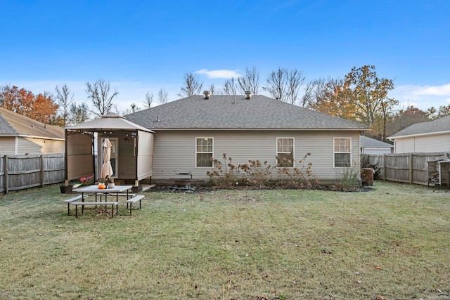 back of house with a gazebo and a lawn