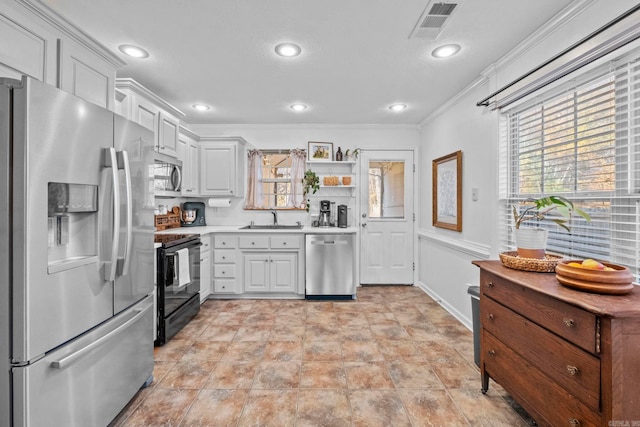 kitchen with white cabinets, appliances with stainless steel finishes, crown molding, and sink