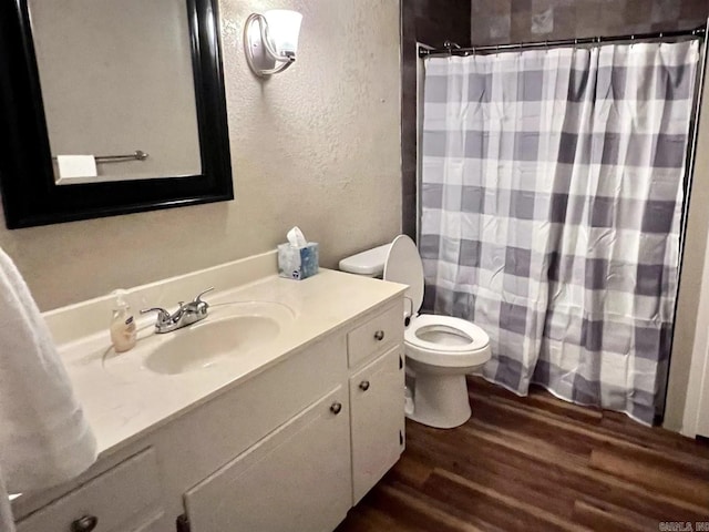 bathroom featuring vanity, hardwood / wood-style flooring, and toilet