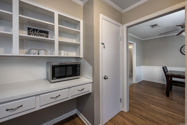 interior space featuring a textured ceiling, crown molding, and dark wood-type flooring