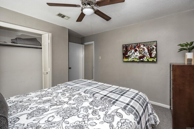 carpeted bedroom with ceiling fan, a closet, and a textured ceiling