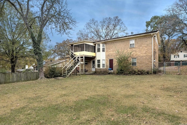 rear view of property with a lawn and a sunroom