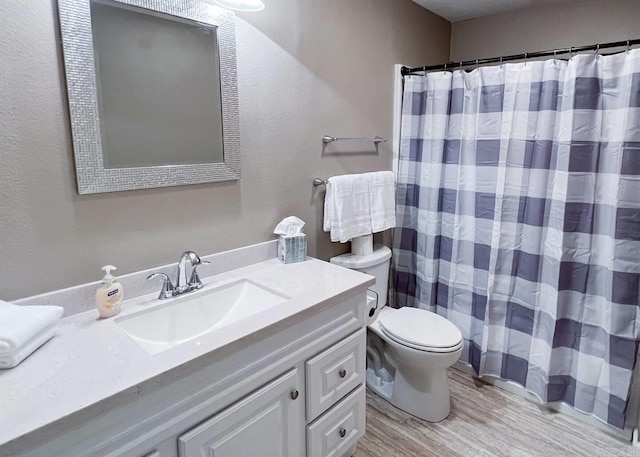 bathroom featuring vanity, hardwood / wood-style flooring, toilet, and walk in shower