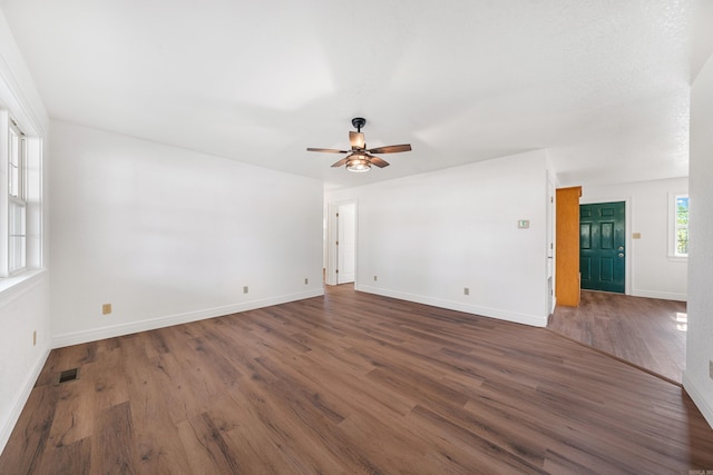 spare room featuring dark hardwood / wood-style flooring and ceiling fan