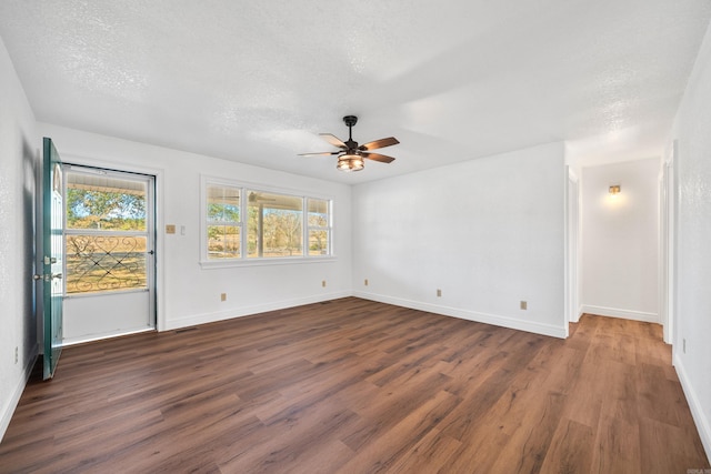 empty room with a textured ceiling, ceiling fan, and dark wood-type flooring