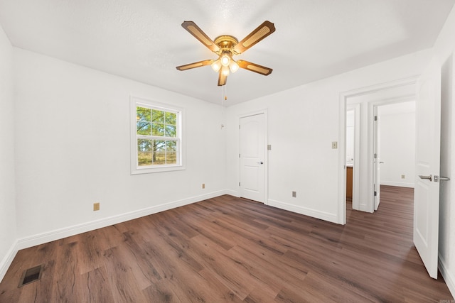 unfurnished bedroom with ceiling fan and dark wood-type flooring