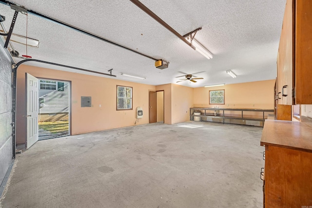 garage featuring electric panel, ceiling fan, and a garage door opener