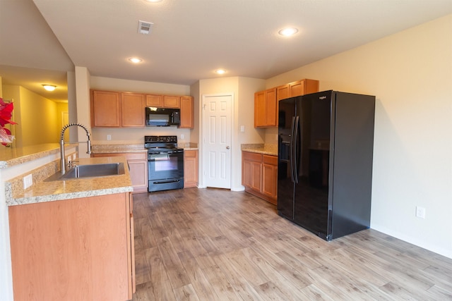 kitchen featuring kitchen peninsula, sink, black appliances, and light wood-type flooring