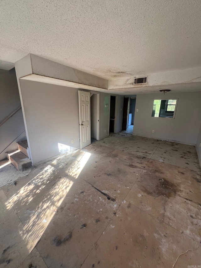 unfurnished room featuring a textured ceiling