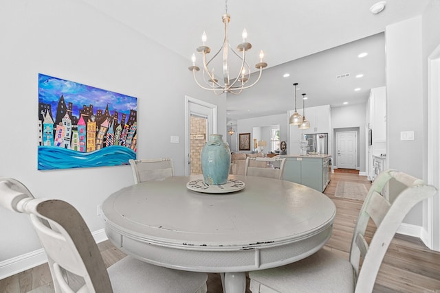 dining space featuring light hardwood / wood-style floors and a notable chandelier