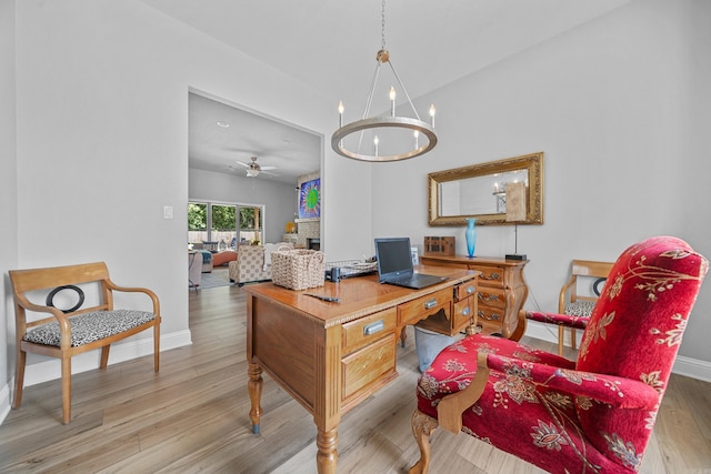 office space featuring ceiling fan with notable chandelier and light wood-type flooring