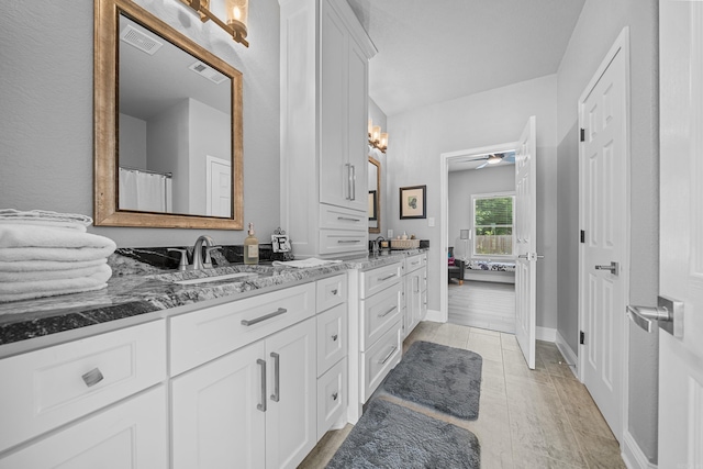 bathroom with wood-type flooring, vanity, and ceiling fan