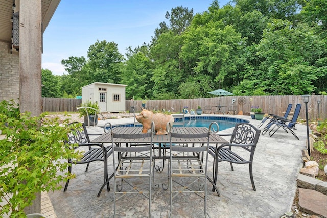 view of patio / terrace with a fenced in pool and a storage unit