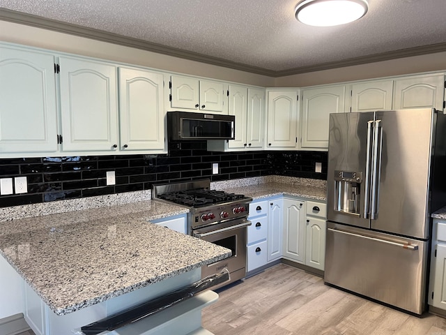 kitchen with white cabinets, light hardwood / wood-style floors, and appliances with stainless steel finishes