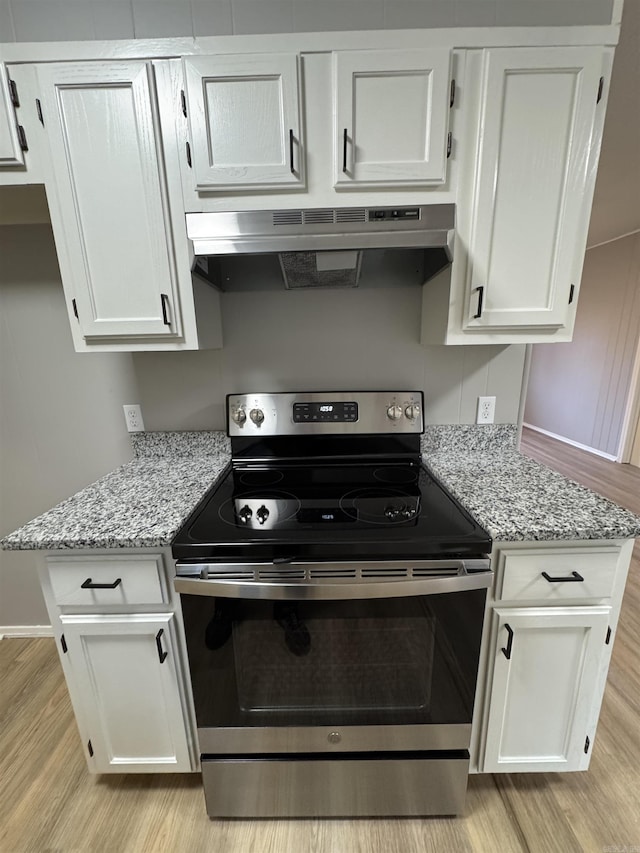 kitchen featuring white cabinets, stainless steel electric range, and ventilation hood