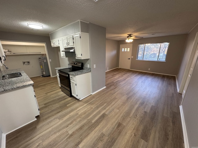 kitchen featuring white cabinets, light stone counters, hardwood / wood-style flooring, and black / electric stove