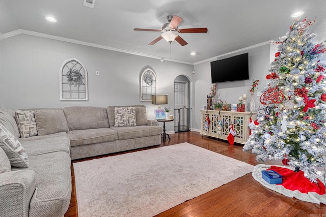 living room with ceiling fan, dark wood-type flooring, vaulted ceiling, and ornamental molding