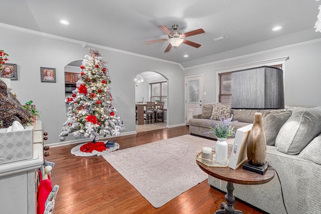 living room featuring hardwood / wood-style floors, ceiling fan, and ornamental molding